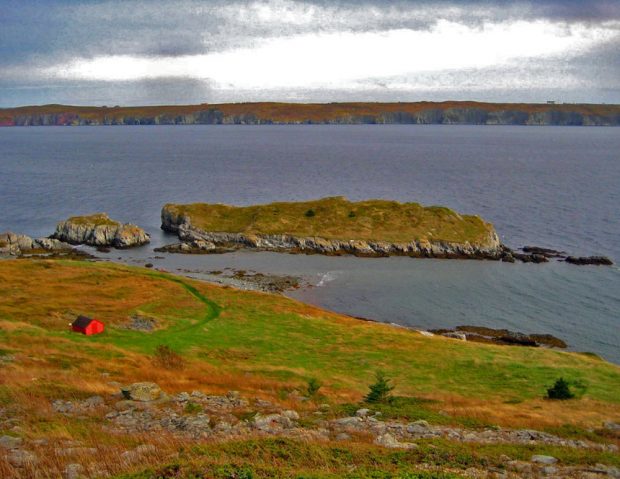 Photographie couleur d’un paysage côtier avec deux petites îles au large.