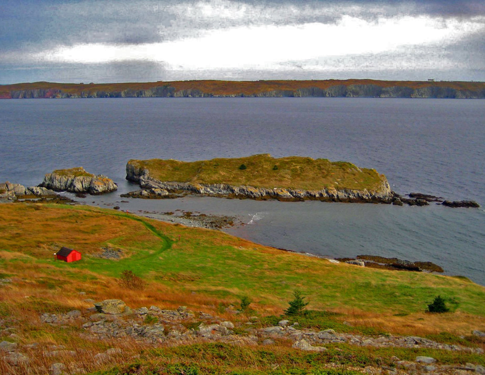 Photographie couleur d’un paysage côtier avec deux petites îles au large.
