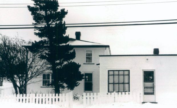 Photographie en noir et blanc de deux bâtiments.