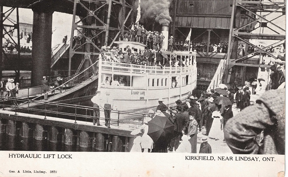 Photo en noir et blanc d’un bateau à vapeur dans l’écluse-ascenseur, observé par une foule