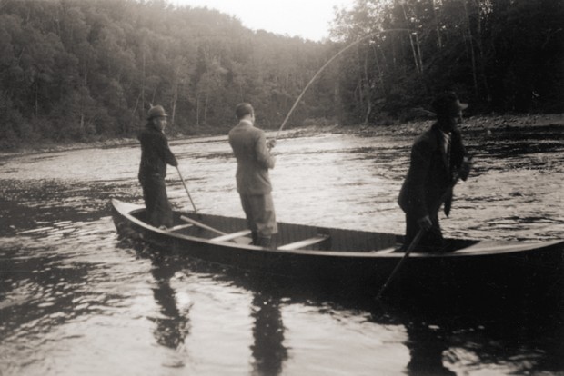 Lord Tweedsmuir pêchant debout dans un canot sur la rivière Mitis