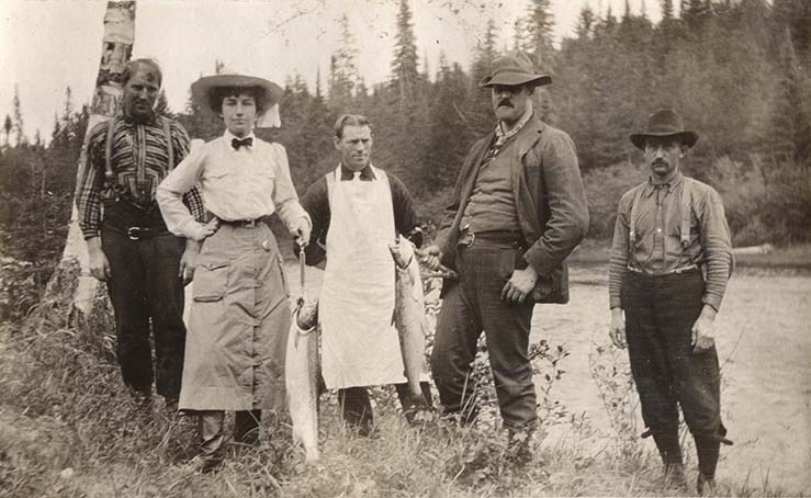 Épreuve argentique d'Elsie Reford accompagnée de quatre guides de pêche de la rivière Tobique montrant deux saumons.