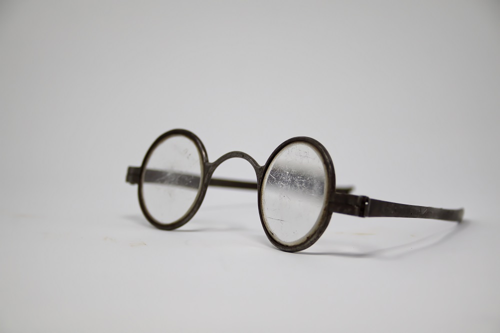 Photographie de lunettes rondes en métal et verre transparent utilisées à l’époque de la Nouvelle-France.