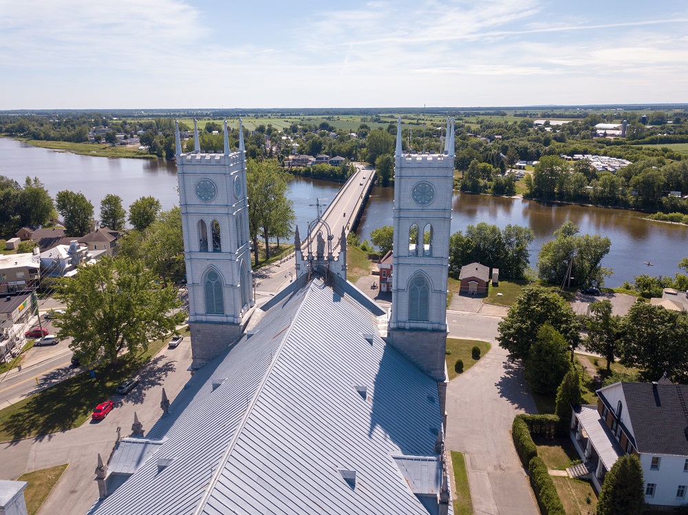 Photographie couleur de l’Église Sainte-Anne surplombant le pont municipal vue du haut des airs.