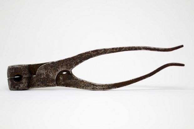 Photographie d'un moule à balle ronde en forme de pinces en fer et métal.