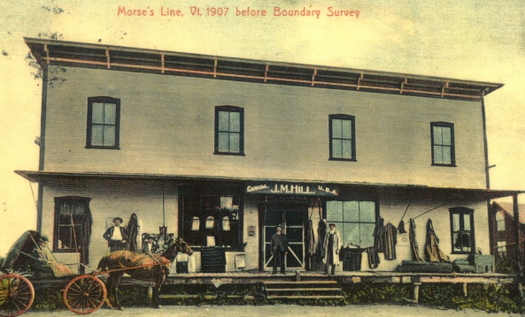 Photo du magasin général de J.M. Hill, aussi port de douane de Morse’s Line; au-dessus de la porte, les mots Canada et USA indiquent de quel côté de la frontière on se trouve.