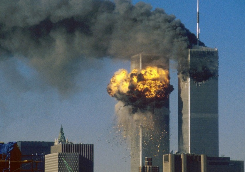 Les flammes consument la tour sud du World Trade Center de New York à gauche, alors qu’une dense colonne de fumée noire s’échappe de la tour nord à droite. 