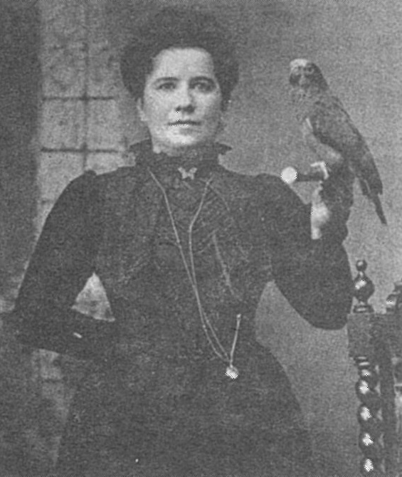 Photo de Queen Lill tenant à la main un perroquet.