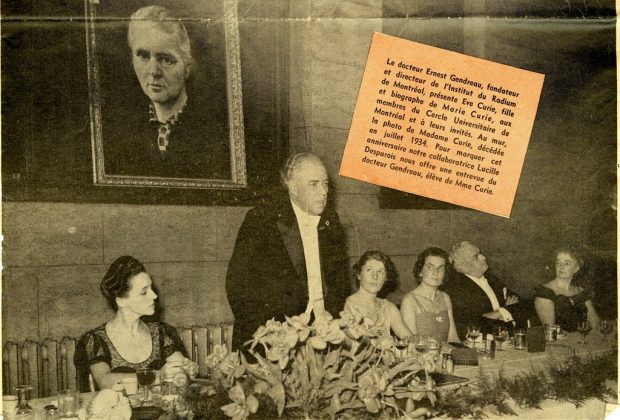 Image noir et blanc qui présente le Dr Ernest Gendreau en costume noir, chemise blanche et nœud papillon blanc en train de faire une allocution dans une salle à Montréal avec quatre femmes et un homme assis à ses côtés. Derrière lui se trouve un portrait de Marie Curie accroché au mur. Un encart explique la circonstance.