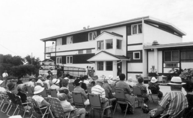 Groupe de personnes assises sur des chaises à l'extérieur d'un bâtiment