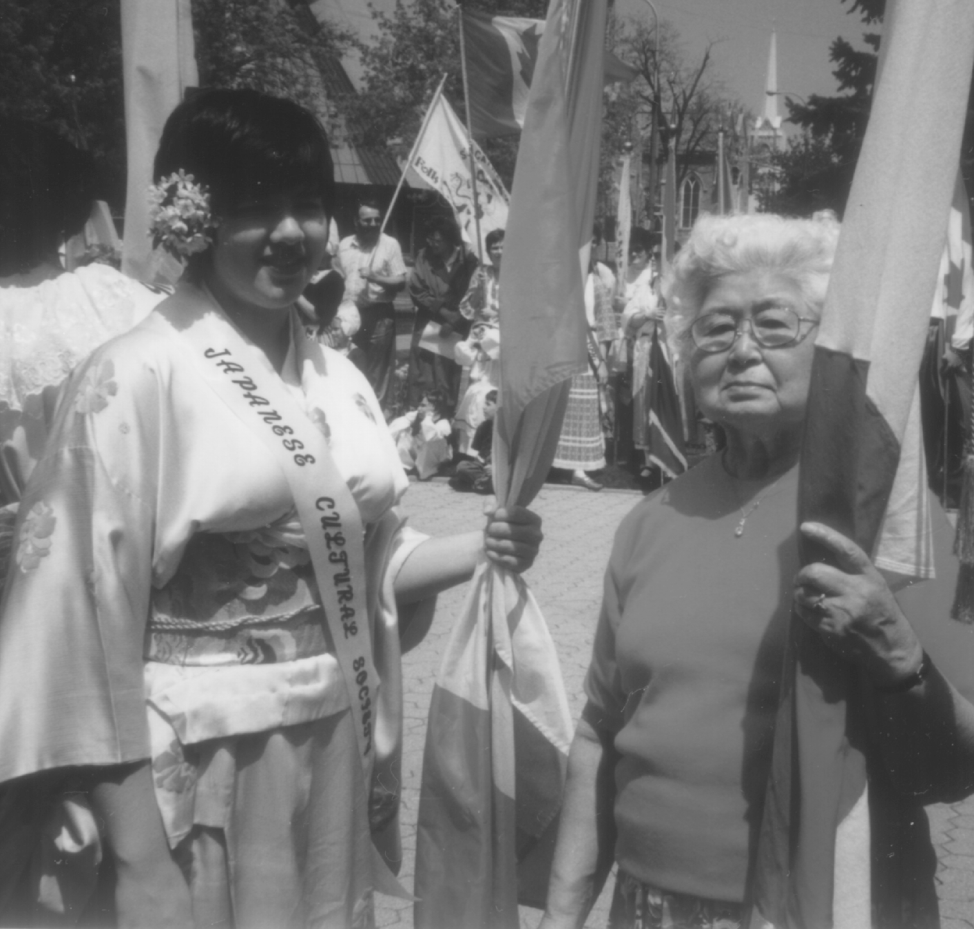 Une jeune femme et une femme âgée debout ensemble tenant des drapeaux