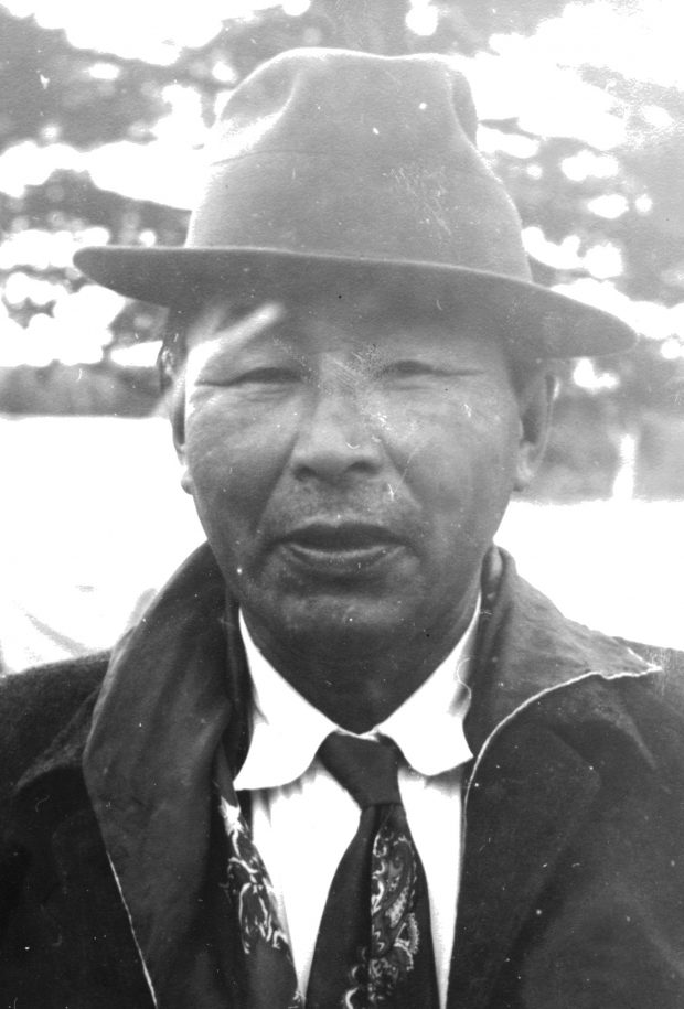 Portrait gros plan d'un ancien chef de Lac Simon. Il porte un chapeau, une chemise, une cravate et une veste. Photo en noir et blanc.