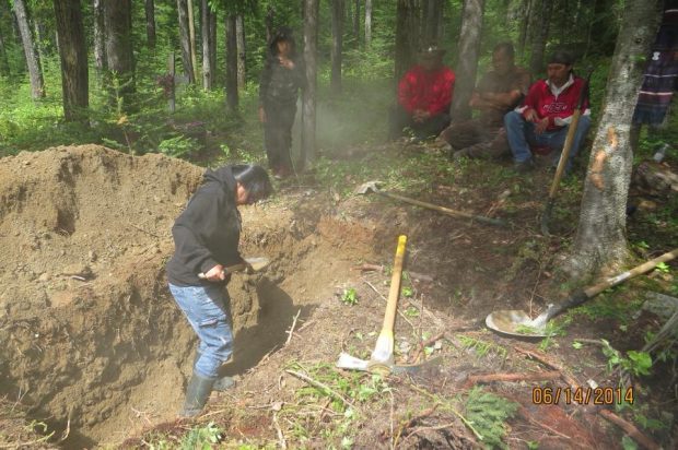 Des Anicinabek creusent une tombe au cimetière familial sur le territoire.