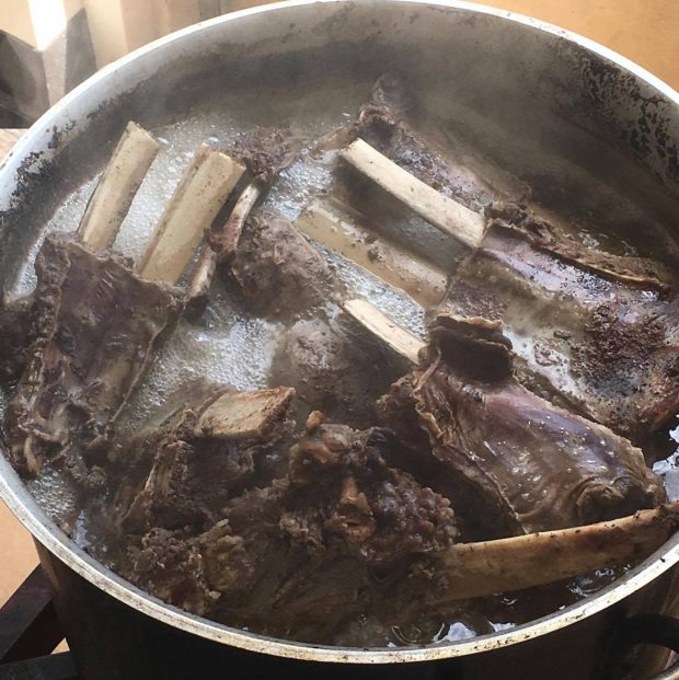 Des côtes d'orignal sont mises à bouillir dans un gros chaudron. Photo en couleur.