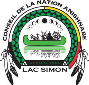 Logo de la communauté de Lac Simon. Au centre, on y voit l'ombre d'une personne assise dans un canot. Un demi-cercle, comme une arche sur le canot, contient quatre couleurs (noir, blanc, jaune, rouge). Sur les deux bouts, il y a des plumes noires et blanches. À part le nom de la communauté, on y lit sa date de création (1962).