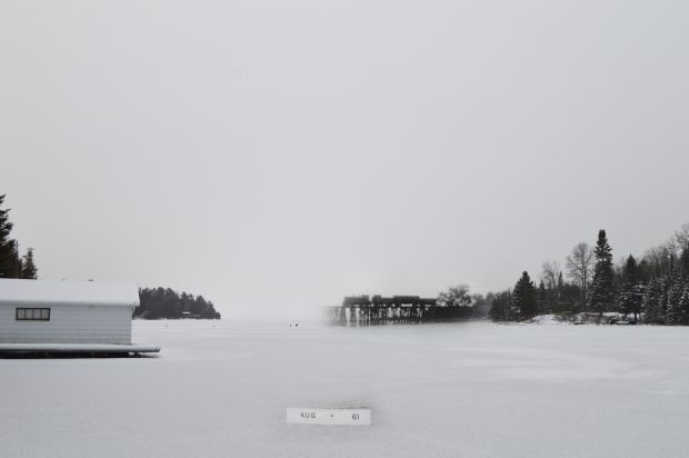 Une photo noir et blanc d'un train traversant un pont superposée à une photo moderne d'une baie.