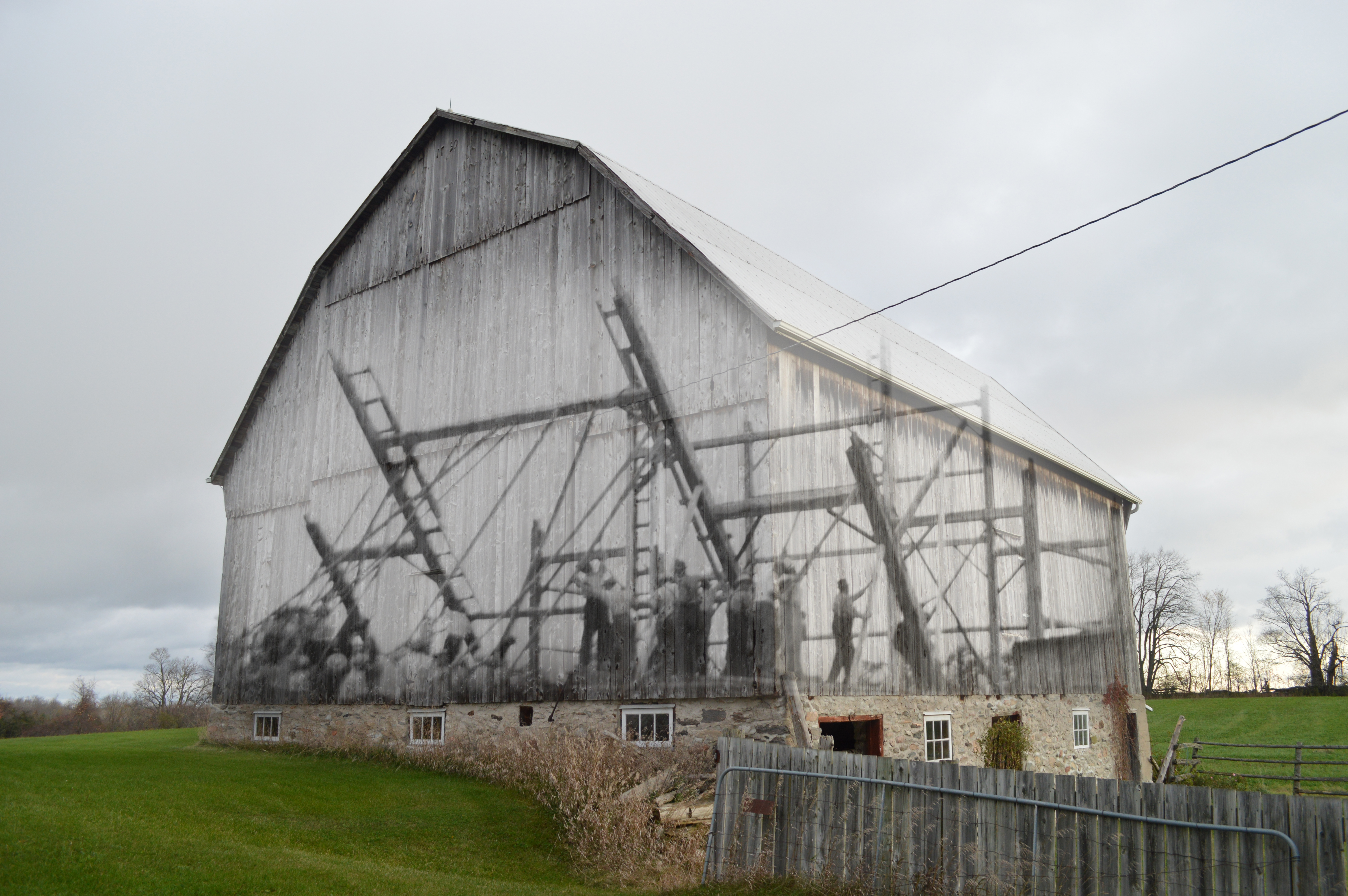 Une image contemporaine d'une grange, superposée avec une image de la corvée qui l'avait levé.