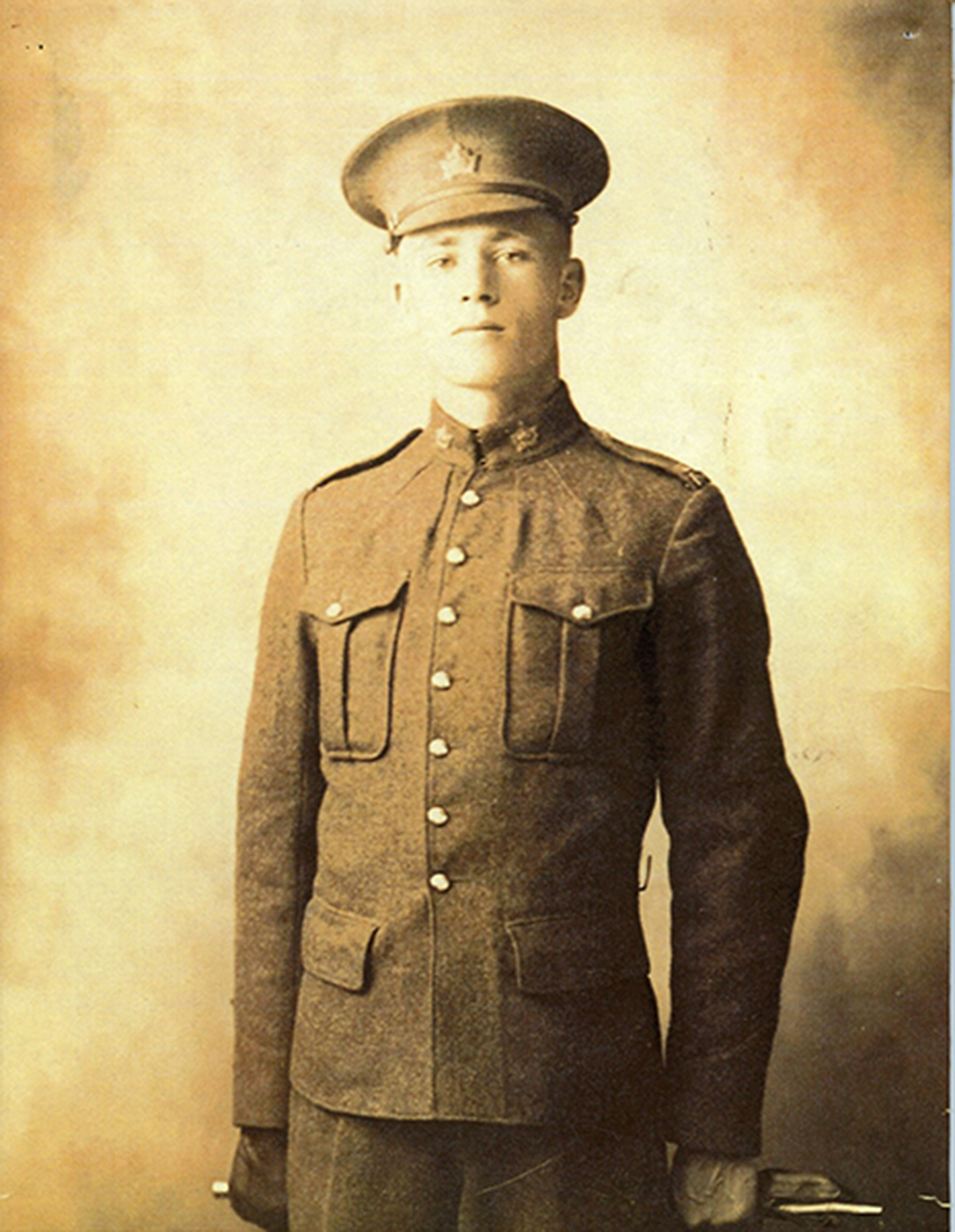 Photo en noir et blanc, légèrement jaunie, d’un soldat en uniforme regardant fixement l’appareil photo.