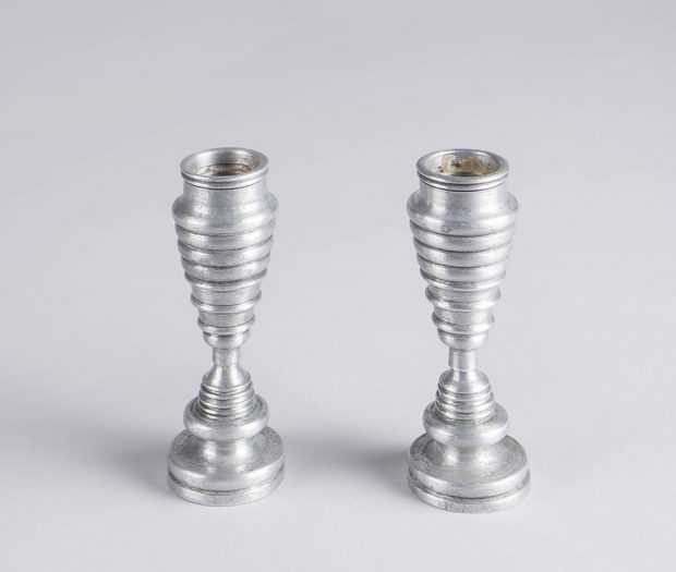 Petits chandeliers en aluminium présentant une série de bourrelets arrondis devenant progressivement plus petits puis plus grands.