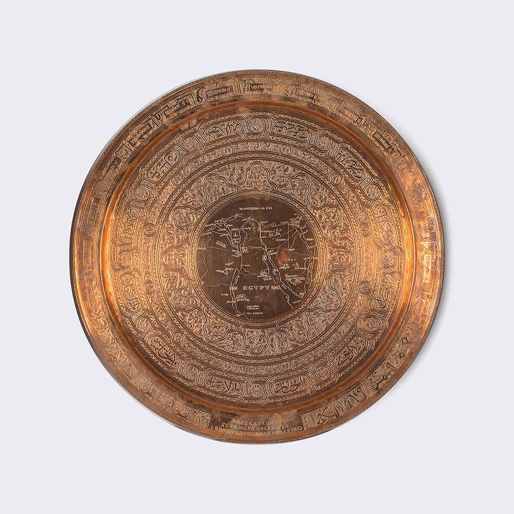 Large plateau en cuivre, montrant une carte au centre, entourée de motifs circulaires.