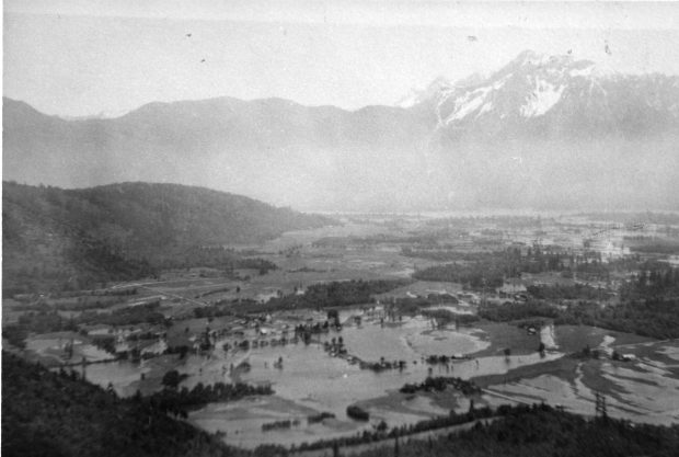 Photo en noir et blanc des champs inondés avec des montagnes en arrière-plan.