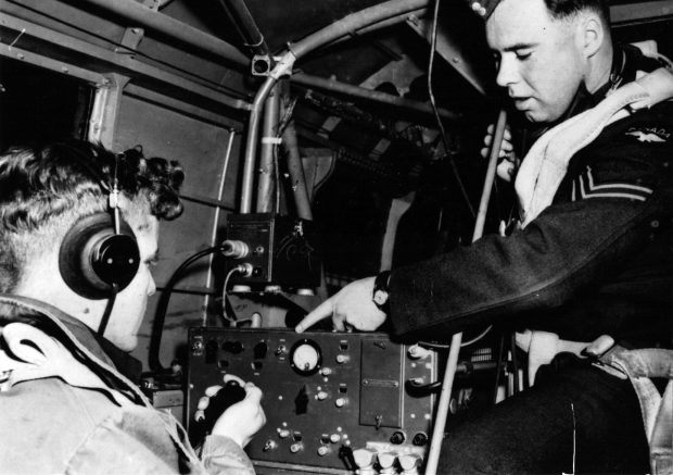 Deux jeunes hommes en uniforme militaire dans un aéronef avec une radio