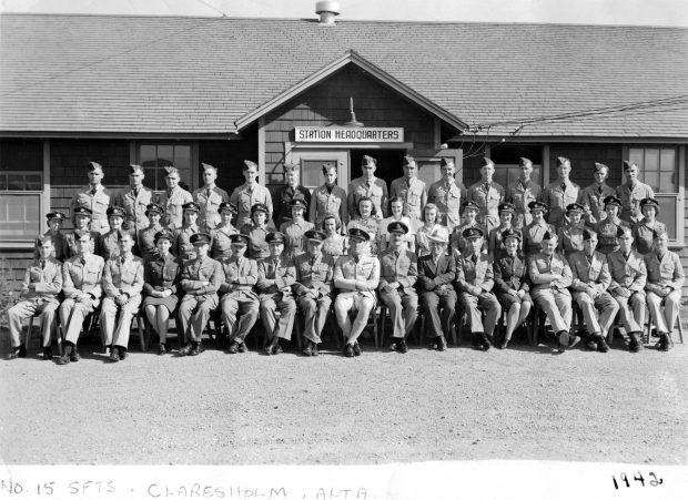 Photo d’un groupe de militaires, hommes et femmes, devant le quartier général de la base