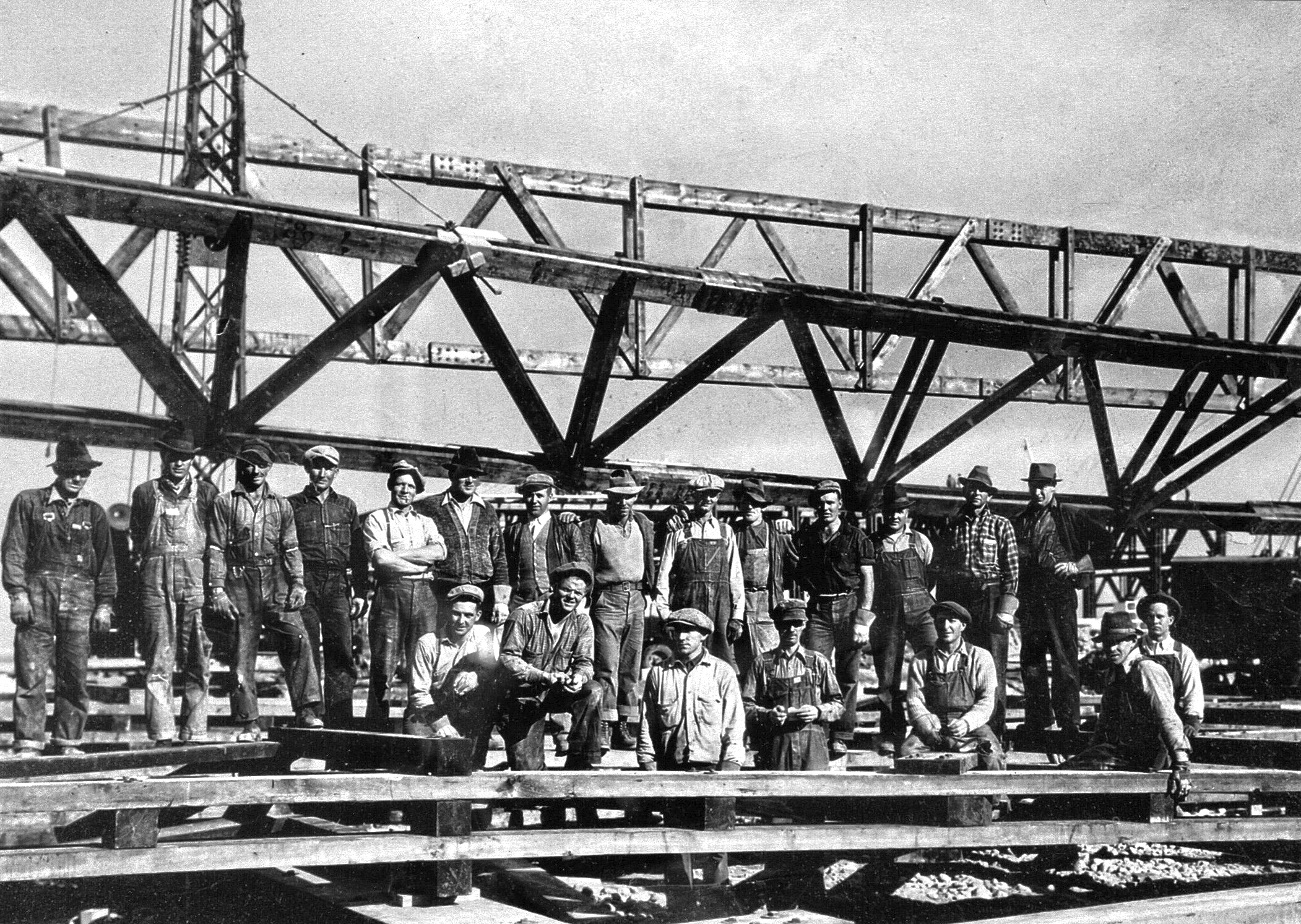 Une équipe de travaux de 21 hommes devant le chantier d’un hangar