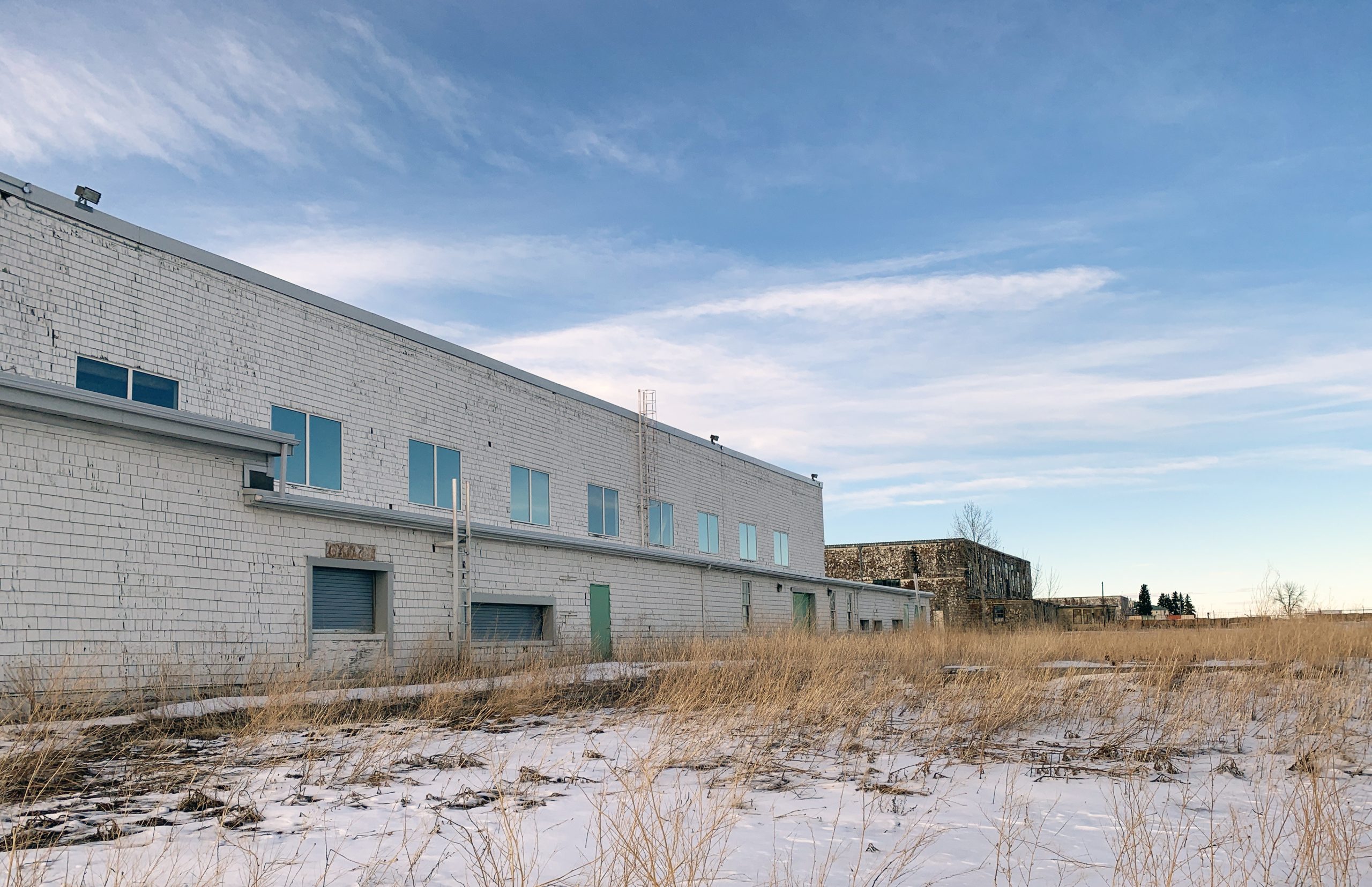 Quatre vieux hangars à avions avec de la neige au sol