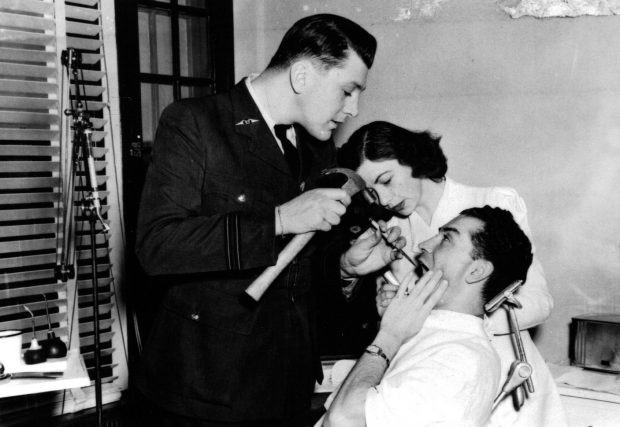 Dentiste militaire opérant un patient avec l’aide d’une infirmière