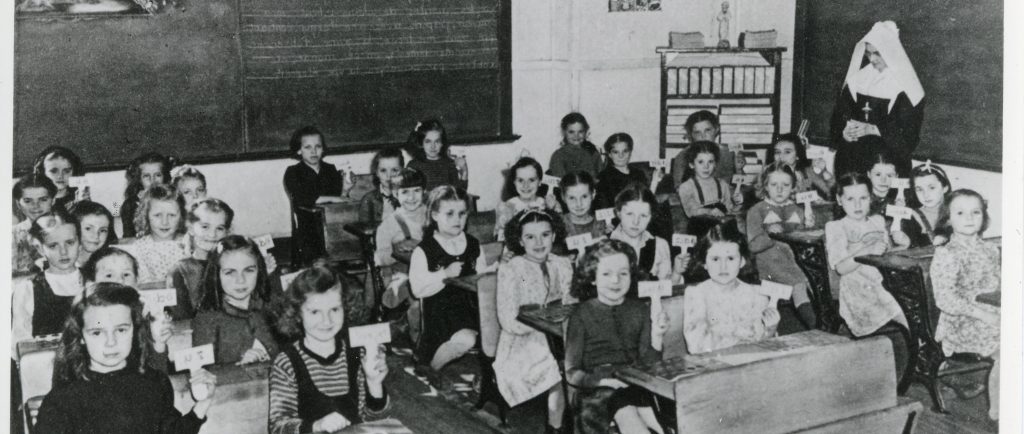 Une trentaine d'écolières assises à leur pupitre. 