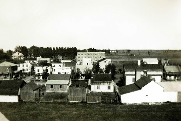 La photo montre le village de Contrecœur. Elle a probablement été prise à partir du toit de l’usine Lafayette. Au fond, on voit la manufacture Joseph Papin ltée ainsi que la luxueuse maison qu’avait fait construire Joseph Papin II. Devant, on voit les maisons et les commerces sur les rues St-Antoine et des Manufactures.