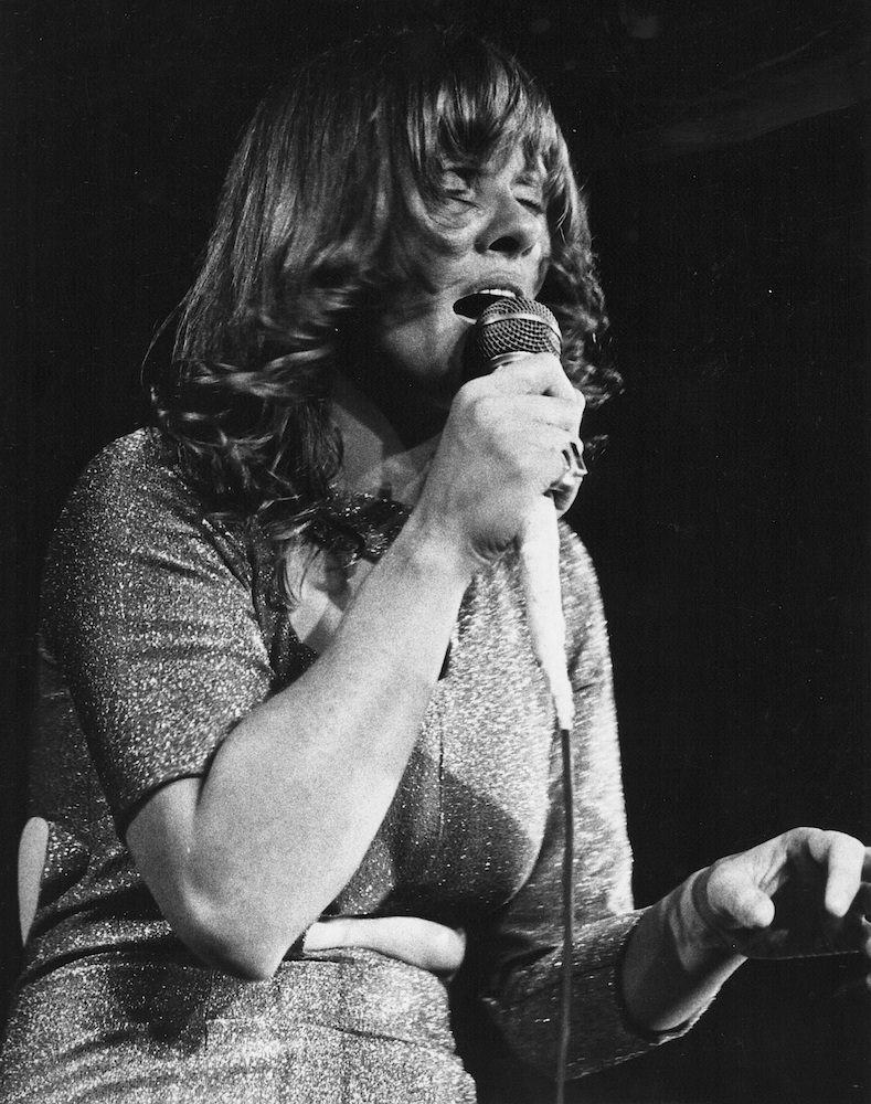 Photo noir et blanc de Diane Dufresne chantant les yeux fermés et portant un micro à sa bouche.