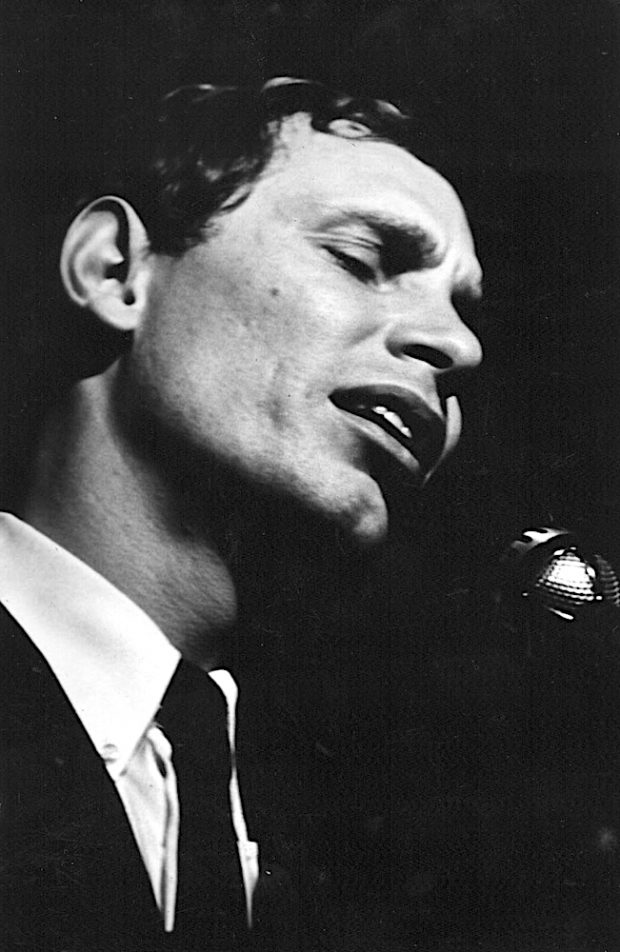 Photo noir et blanc de Jean-Pierre Ferland chantant, en veston cravate.