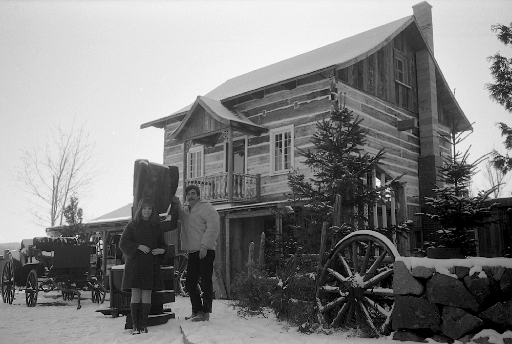 Black and white photo of Marie-Josée Longchamp and Gilles Mathieu in front of his residence on La Butte grounds.