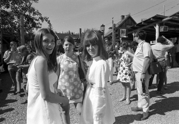 Photo noir et blanc d’un groupe de jeunes femmes en robes d’été parmi les spectateurs à l’extérieur de La Butte.