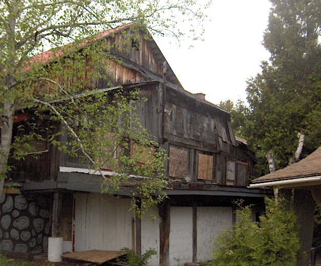 Photo couleur de La Butte abandonnée et placardée en 2004. Le lieu est délabré et tombe en ruine. 