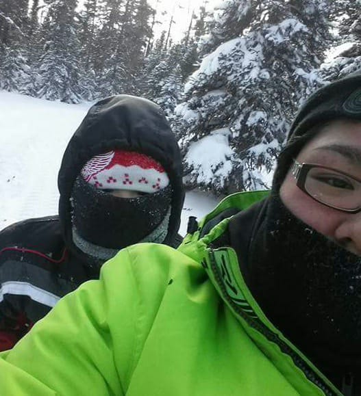 Gros plan de deux personnes en manteau d’hiver dans la forêt enneigée