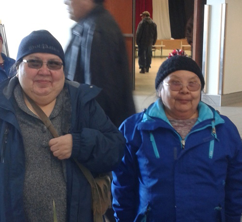 Deux femmes portant chapeau et lunettes regardent l’appareil photo