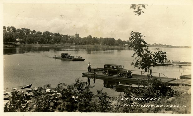 Photographie d’époque en teinte sépia. Elle montre deux voitures sur deux traverses à traille, reliant l’est de l’île Jésus et le village de Sault-au-Récollets sur l’île de Montréal. En bas à droite, il est écrit à la main : La traverse Saint-Vincent-de-Paul. 