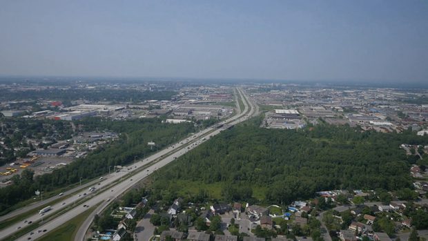 Photographie aérienne en couleur. Vue sur l’autoroute Jean-Noël Lavoie et le secteur industriel de Laval.