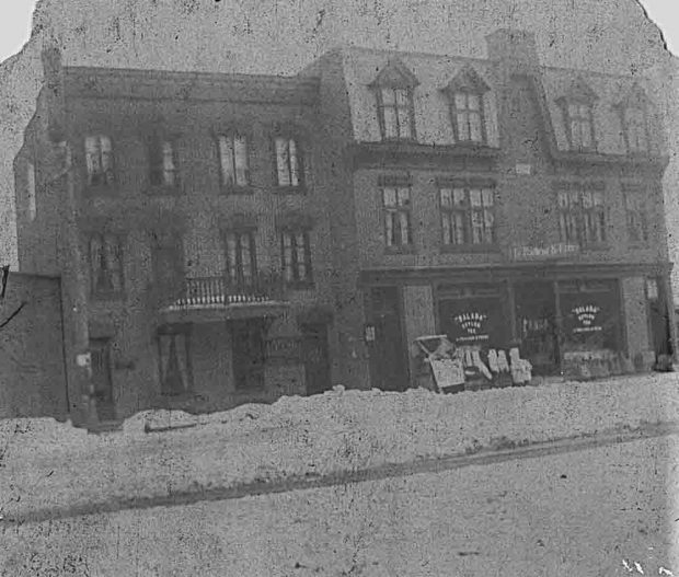 Photo noir et blanc de la façade du commerce LePailleur et  Frères. Il y a de la neige sur le chemin.