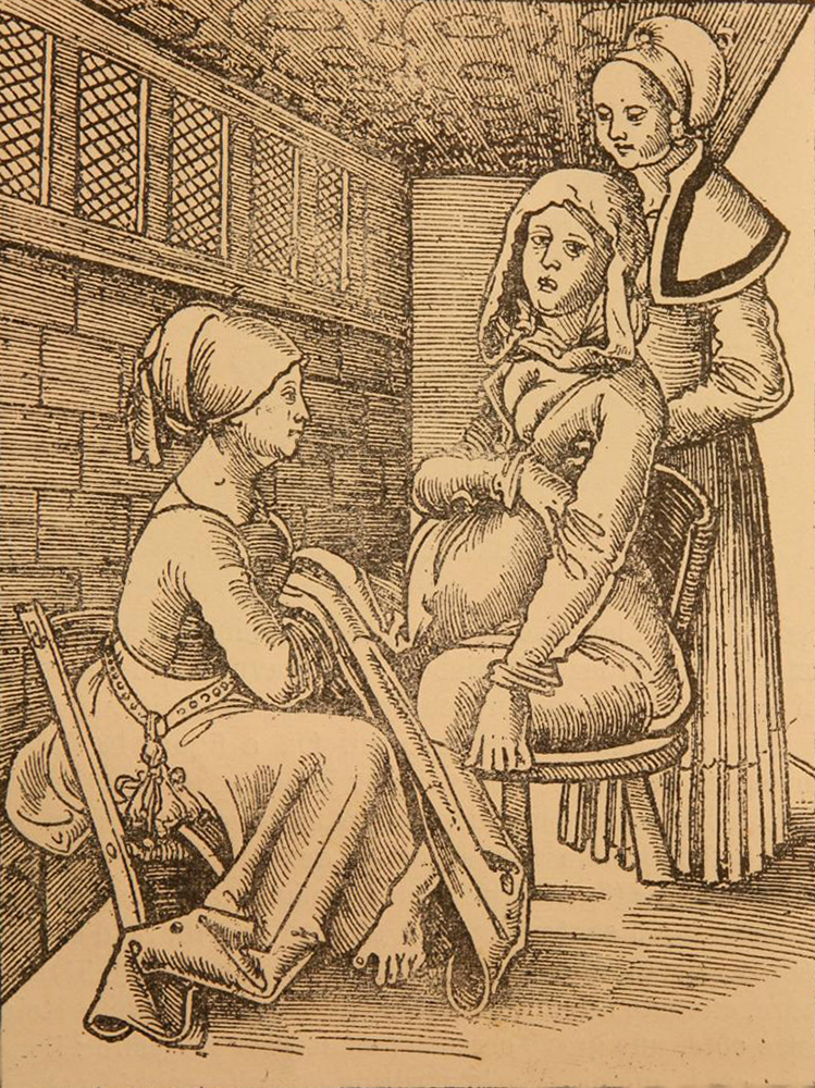 Illustration tirée d'un livre. Il s'agit d'une femme assise sur une chaise, avec une sage-femme à ses pieds et une autre derrière elle qui la soutient.