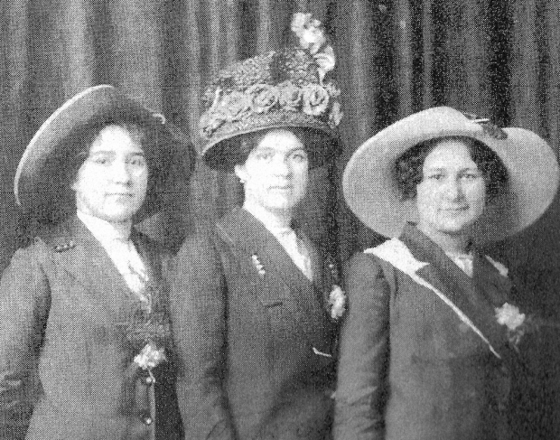 Trois femmes portant chapeaux et manteaux