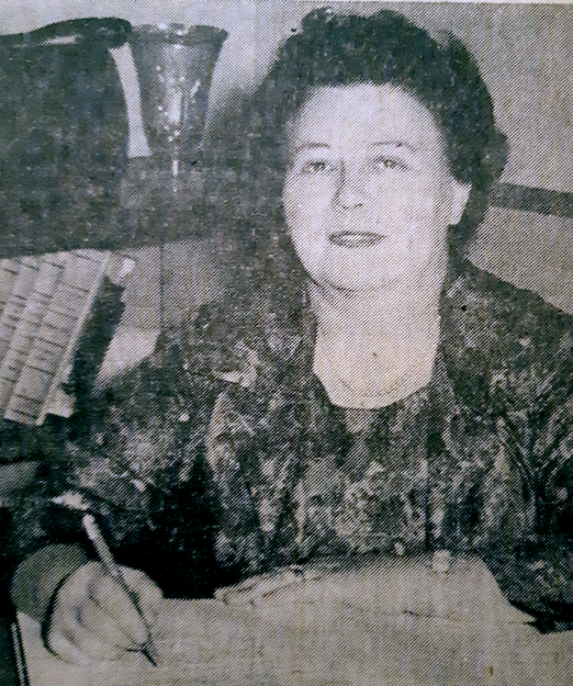 Photo en buste d'une femme assise et écrivant