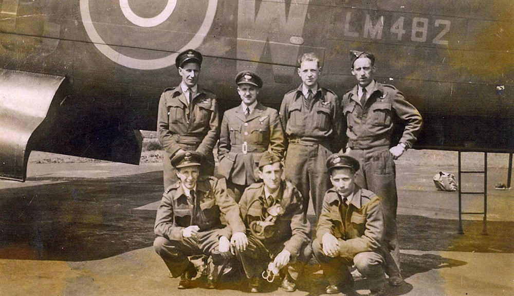 Crew posing in front of military plane