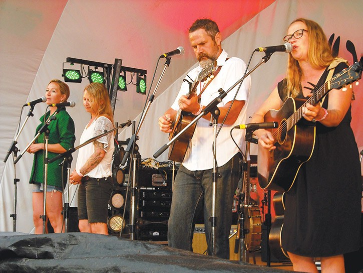 Four musicians and singers performing on stage