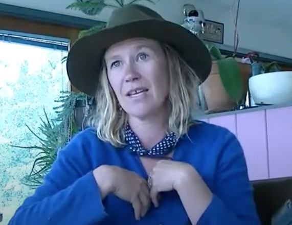 Image en buste d'une femme portant un stetson assise dans une cuisine