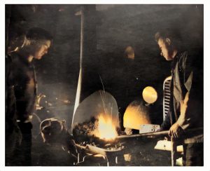 Deux hommes à une forge