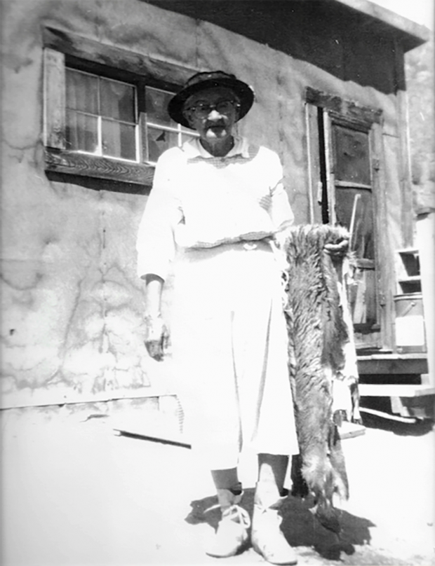 Femme tenant une fourrure devant une maison